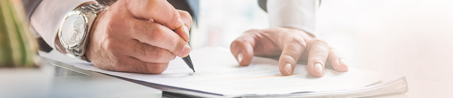 Man signing a document at the offices of Sydney wills and estates lawyers, Pigott Stinson